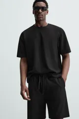 Bermuda negra de corte relaxed fit, con cintura elástica ajustable con cordón, bolsillos frontales y bolsillo trasero de parche.