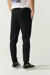 Pantalón de jogging gris con puños y logo estampado.