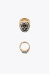 Pack de dos anillos metálicos, uno dorado y otro plateado, con diseño labrado.