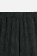 Pantalón negro de corte amplio con cintura elástica ajustable con cordón, bolsillos delanteros y detalle de bolsillo trasero de vivo.