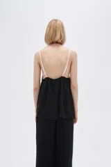 Musculosa de poliéster con breteles finos, diseño color block, corte holgado, escote en V y elástico en el ruedo.