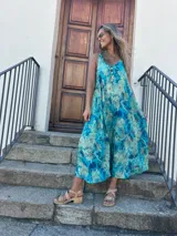 Vestido largo turquesa con estampado abstracto, corte al sesgo y escote en V tanto en la parte delantera como en la trasera.