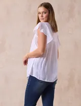 Blusa blanca de gasa con broderie, cuello a la base, escote en V y lazo de ajuste. Delantera broderie con corte y frunces. Manga corta volado de broderie. Espalda con corte y frunces.