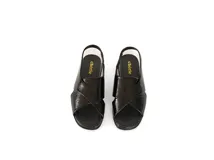 Sandalia de charol negro con tiras cruzadas, talón con elástico interno y plantilla de cuero acolchada.