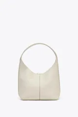 Bolso tipo saca de piel color blanco hueso con efecto granulado. Tiene asa de hombro y cierre con imán. Incluye cartera con bolsillo extraíble.