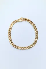 Collar dorado tipo cadena de eslabones metálicos gruesos con cierre de gancho y clip.