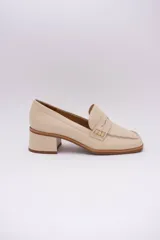 Mocasines clásicos de cuero color beige con taco cuadrado y detalle de antifaz.