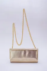 Cartera tipo sobre color beige con textura granulada y correa de cadena dorada.