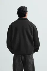 Sudadera azul marino de cuello alto con cierre frontal de cremallera, corte relaxed fit, manga larga y terminaciones en rib.