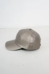 Gorra de béisbol color gris topo, confeccionada en ecocuero, con visera curva y correa ajustable en la parte posterior.