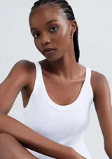 Musculosa slim color ocre, de tela acanalada con cuello redondo y sisas anchas.