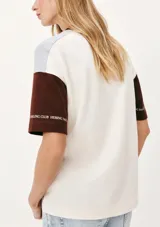 Camiseta de mangas cortas con cuello redondo y corte amplio. Presenta un diseño con bloques de color y estampados con motivos náuticos y geométricos.