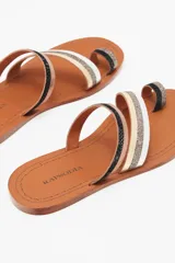 Sandalias bajas con tiras finas de cuero vacuno color negro, plateado y dorado.