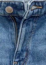 Pantalón de jean azul de corte recto, tiro medio, con cinco bolsillos, trabillas y aberturas en el bajo.