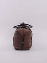Bolso de viaje negro con detalles en cuero marrón, doble asa de mano y cierre superior con cremallera.