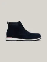 Botines Tommy Hilfiger de hombre, color azul marino, confeccionados en ante con interior de poliéster y suela de goma. Presentan cordones, logo Hilfiger en el tobillo y detalle distintivo en el talón.