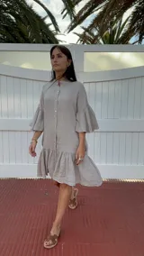 Vestido de lino con cuello mao y botones de nácar, detalles de volados en mangas y parte inferior, y bolsillos.