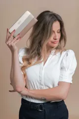 Billetera rectangular con cierre de cremallera, confeccionada en símil cuero con franjas horizontales en tonos blanco, gris y negro.