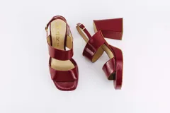 Sandalias de plataforma color borgoña, confeccionadas en charol. Tienen dos tiras anchas sobre el empeine, pulsera con hebilla al tobillo y taco cuadrado de 9 cm.