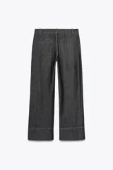 Pantalón de jean azul oscuro, de tiro alto y corte bootcut. Presenta bolsillos delanteros y traseros.