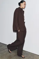 Pantalón marrón de tiro medio y pierna ancha, con cintura elástica ajustable con cordones.