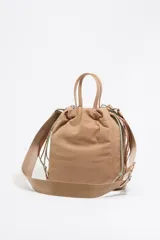 Mochila shopper de nylon color beige, con doble asa de mano, tiras ajustables y dos bolsillos frontales con cierre.