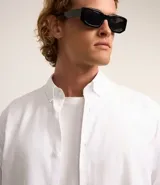 Camisa blanca de algodón, manga larga con botonadura frontal y cuello camisero.