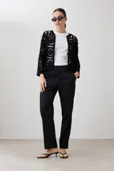 Chaqueta de hilo color negro, tejida a crochet con diseño de flores caladas. Tiene mangas 3/4 y cuello redondo.