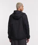 Campera negra con capucha, cierre frontal con cremallera y bolsillo de malla en el pecho.
