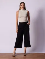 Pantalón capri plisado negro, marca Dictionary, con pretina ancha elastizada y bolsillos delanteros.