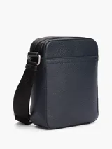 Bandolera Tommy Hilfiger de poliuretano granulado color azul marino, con correa ajustable de tejido jacquard con el logo de la marca. Tiene un compartimento principal con cierre, bolsillo interior con cremallera y bolsillo exterior abierto.
