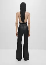 Pantalón de cuero negro, de tiro alto y corte acampanado.