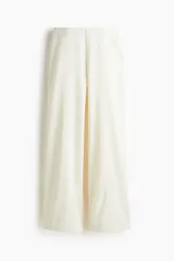 Pantalón de tiro alto color blanco, con elástico oculto en la cintura y piernas amplias con costura pespunteada doble adelante.