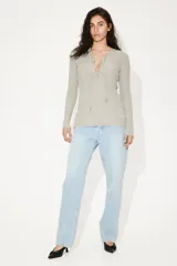 Blusa larga color verde claro en punto acanalado, con escote en V profundo y tiras para atar con cuentas en los extremos.