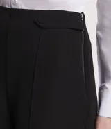 Shorts negros de sastrería con detalle de botones en los laterales y pliegues.
