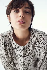 Blusa de tejido liviano con estampado de leopardo en blanco y negro. Modelo entallado con cuello redondo, cierre de botones y mangas globo tres cuartos con puños elásticos.