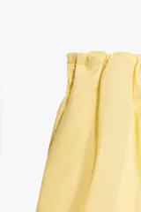 Pantalón culotte amarillo de tiro medio con cintura elástica y bolsillos laterales ocultos en la costura.