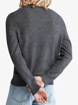 Sweater gris de punto liso, con cuello redondo y mangas largas. Tiene el logo de Calvin Klein bordado en el pecho.