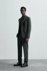 Pantalón de vestir gris oscuro, corte slim fit, confeccionado en tejido con 17% de lana. Cuenta con bolsillos frontales y traseros de vivo con botón. Cierre frontal con cremallera y botón.