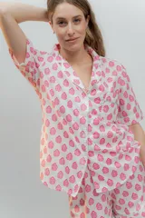 Conjunto de pijama de algodón a rayas verticales rosas y blancas, con detalles en celeste. Incluye camisa de manga corta con botones y bolsillo en el pecho, y shorts con cintura elástica.