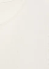 Musculosa blanca de tejido de punto fino, sin mangas y cuello redondo. Diseño entallado.