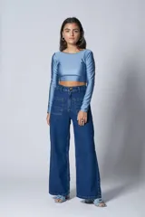 Top corto celeste de lycra, con escote redondo y mangas largas.