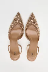 Zapato destalonado color beige con puntera fina, confeccionado en mesh con abalorios y tira trasera elástica. Tacón fino de 8 cm.