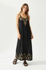 Vestido largo negro con breteles finos y bordado dorado en el escote y el ruedo.