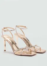 Sandalias doradas de tacón fino con tiras finas con strass y cierre de hebilla.