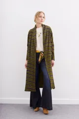 Kimono largo verde oliva con estampado batik en tonos morados. Tiene mangas largas, bolsillos laterales y se ata a la cintura con un cinturón blanco y negro.
