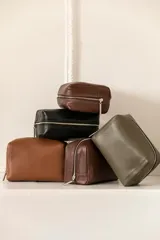 Necessaire de cuero vacuno color marrón, con cierre superior y bolsillo interno. Ideal para artículos de tocador.