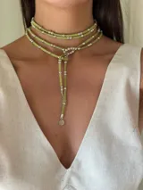 Collar doble de cordón verde con cuentas metálicas, ajustable con ojal en una punta.