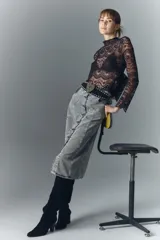 Falda midi de denim rígido, color gris claro lavado, con botones metálicos grabados en el frente y recortes verticales.