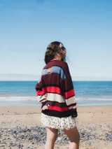 Buzo tejido con diseño de rayas horizontales en tonos marrón, azul, verde y blanco.